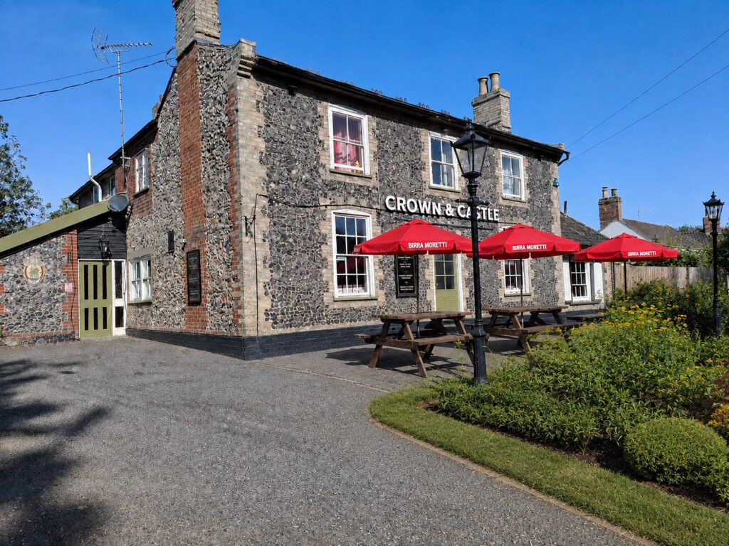 The Crown and Castle in Risby, with outdoor tables and red parasols